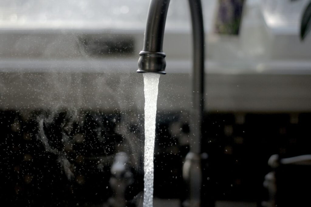 A grey faucet with running water